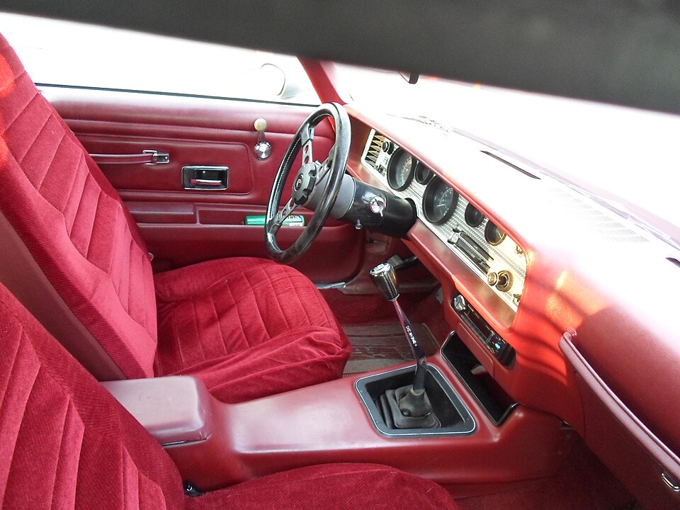 Red cloth front seats and interior of a second-generation Pontiac Trans Am